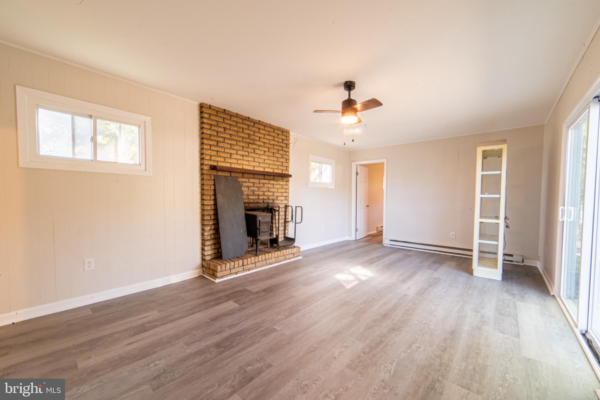 519 Berkeley Drive Browns Mills, NJ 08015 - Photo 23 of 25 an empty room with wooden floor fireplace and windows