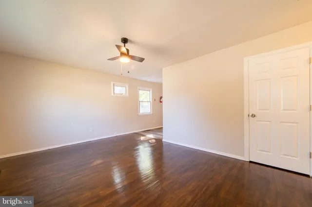a view of a room with wooden floor and ceiling fan