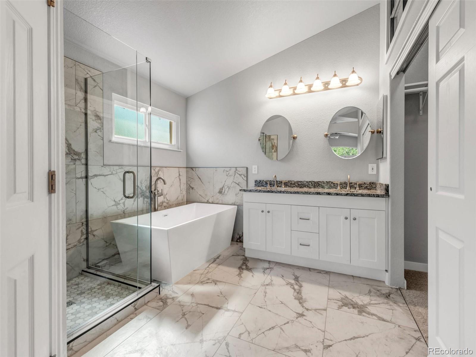9454 Wolfe Place Highlands Ranch, CO 80129 - Photo 1 of 31 a spacious bathroom with a granite countertop sink mirror and bathtub