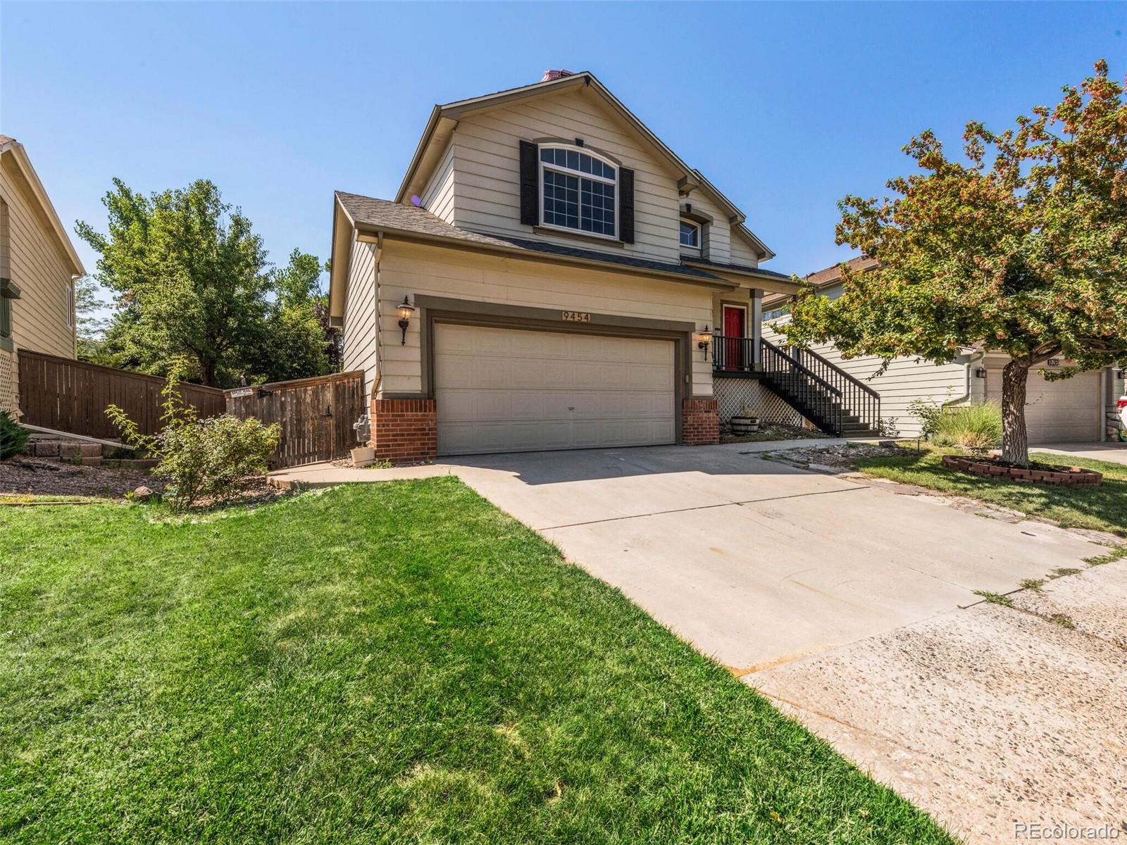 9454 Wolfe Place Highlands Ranch, CO 80129 - Photo 23 of 31 a front view of a house with a yard and garage