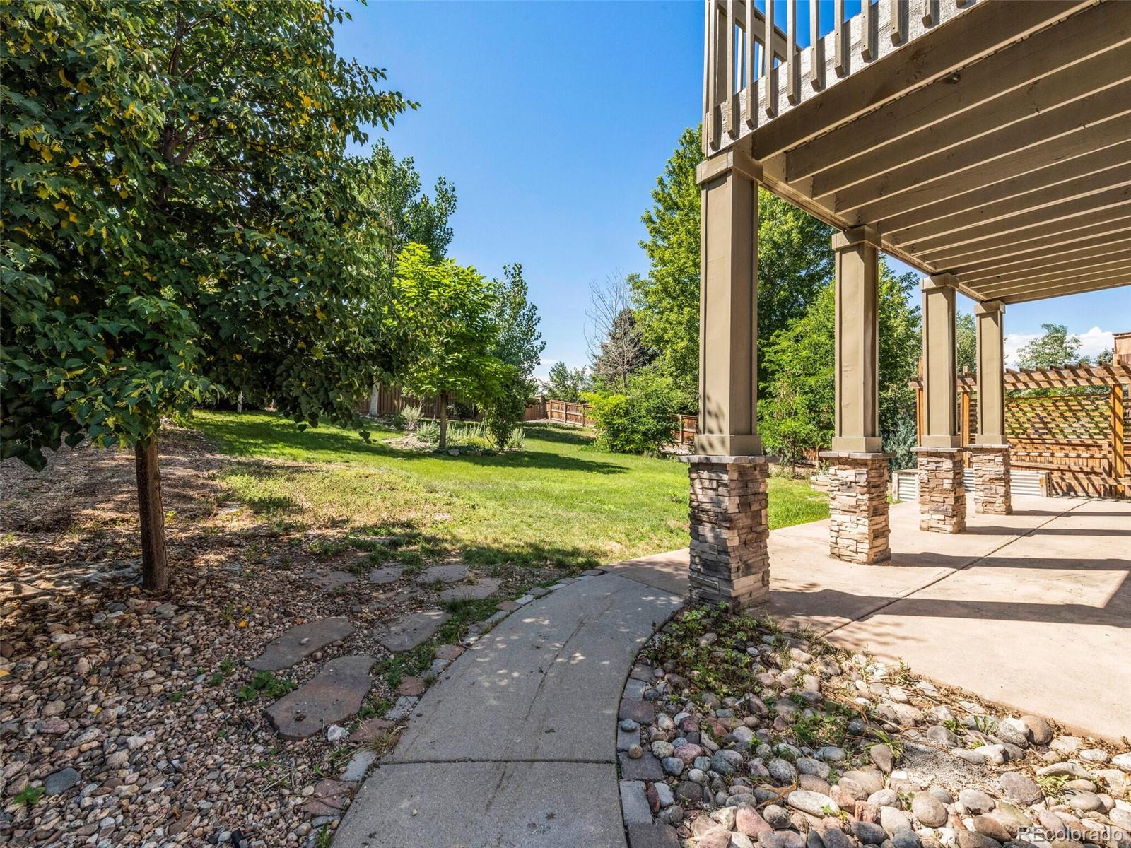 9454 Wolfe Place Highlands Ranch, CO 80129 - Photo 25 of 31 a tree in a yard with wooden fence