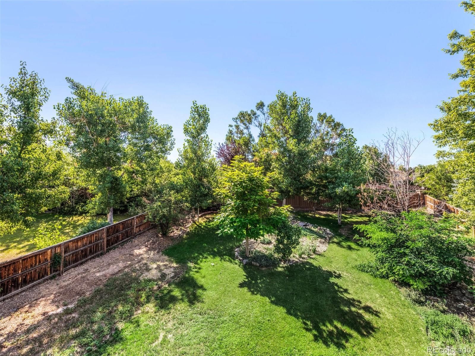 9454 Wolfe Place Highlands Ranch, CO 80129 - Photo 28 of 31 a view of a yard with plants and a bench