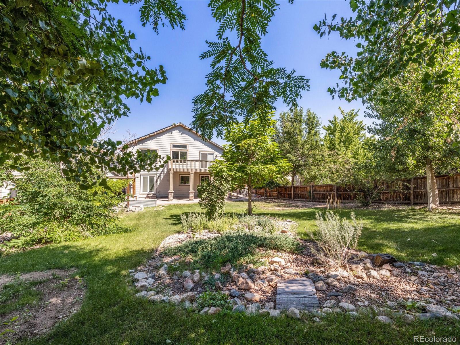 9454 Wolfe Place Highlands Ranch, CO 80129 - Photo 29 of 31 a backyard of a house with a garden and outdoor seating