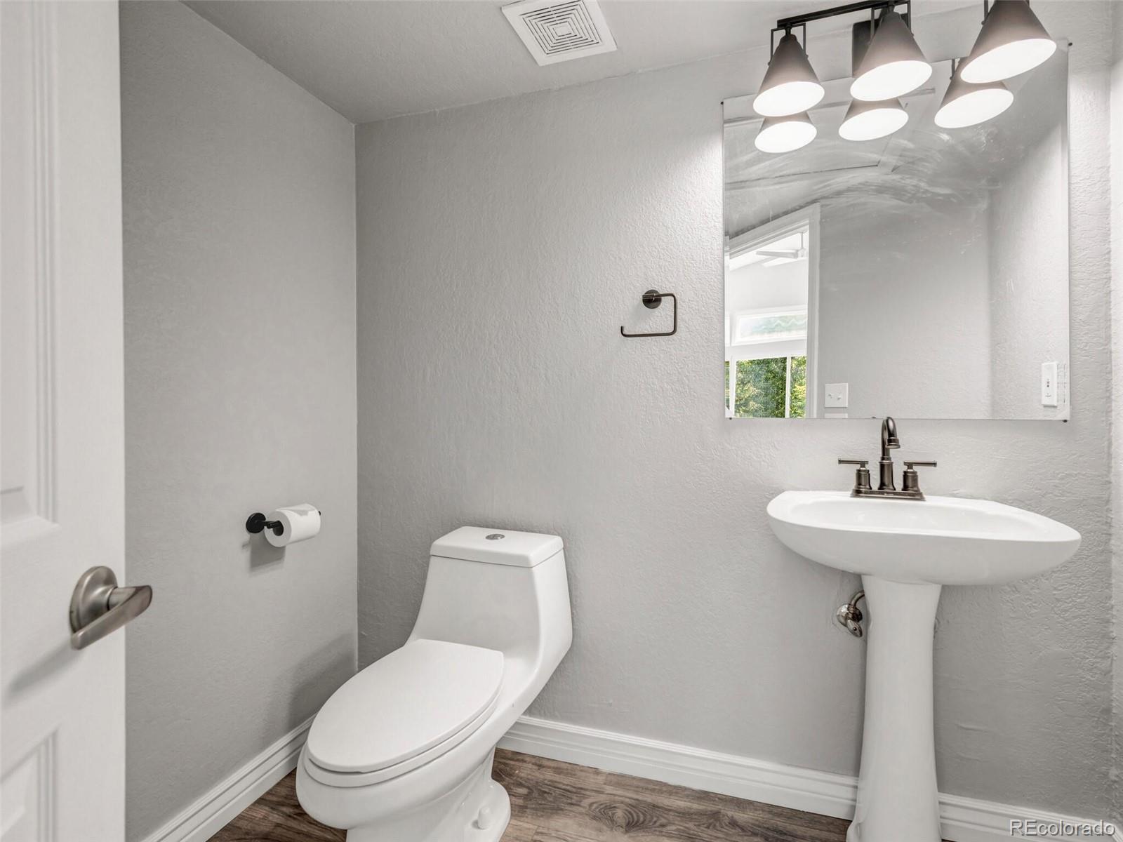 9454 Wolfe Place Highlands Ranch, CO 80129 - Photo 4 of 31 a bathroom with a toilet sink and mirror