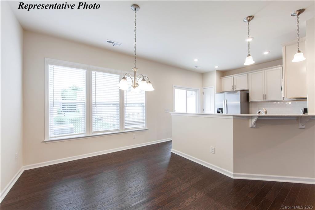 745 Elders Story Road, Unit 354 Fort Mill, SC 29708 - Photo 5 of 20 a view of a kitchen with kitchen island a sink wooden floor and a window