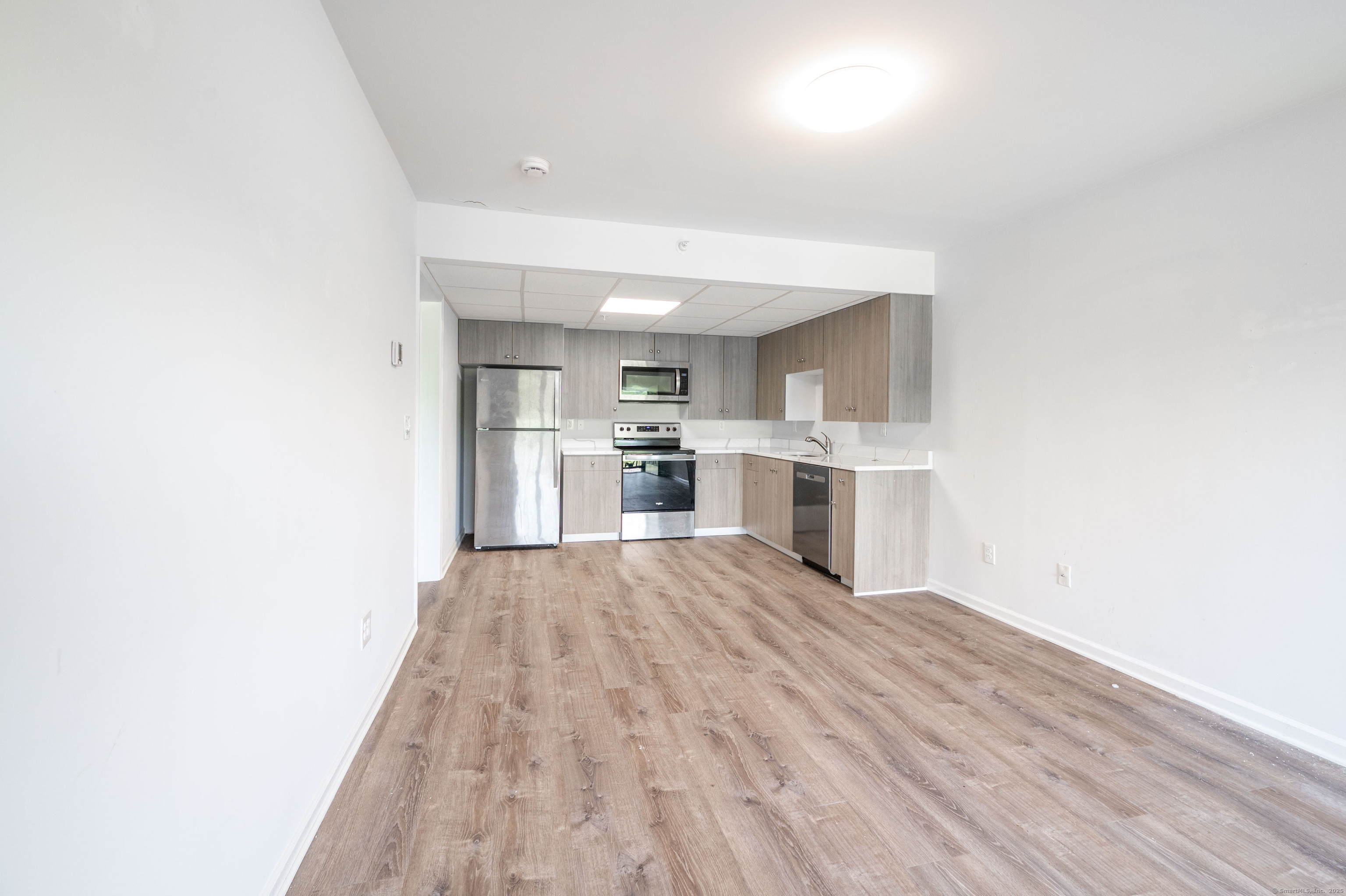 1030 Federal Road, Unit 201 Brookfield, CT 06804 - Photo 7 of 20 a view of a kitchen with wooden floor and a kitchen