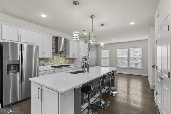 a kitchen with a table chairs refrigerator and microwave