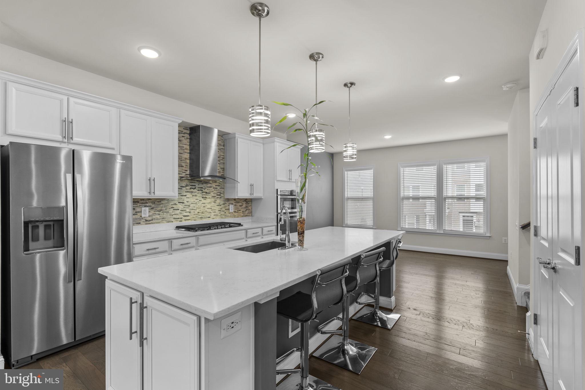 17357 Redshank Road Dumfries, VA 22026 - Photo 11 of 29 a kitchen with a table chairs refrigerator and microwave