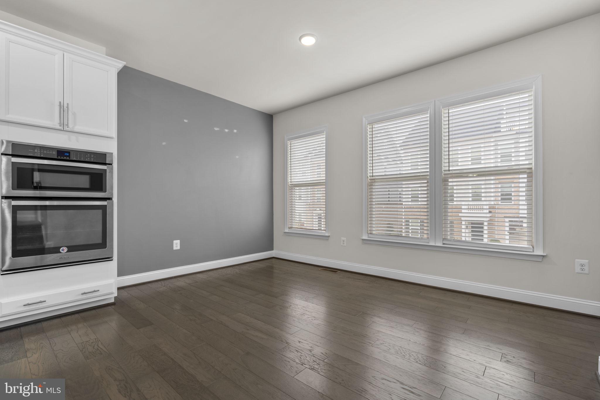 17357 Redshank Road Dumfries, VA 22026 - Photo 14 of 29 an empty room with wooden floor cabinet and windows