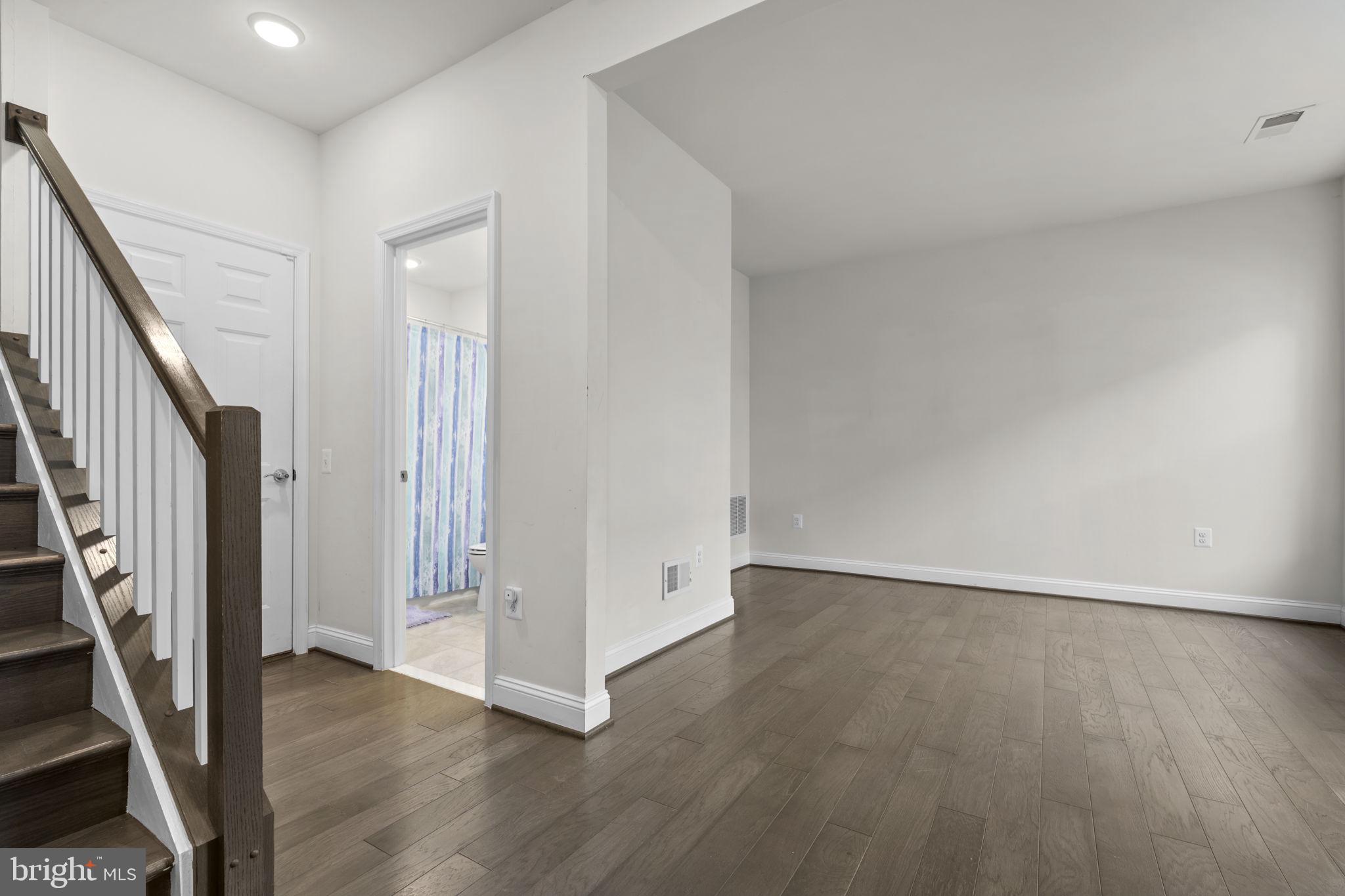 17357 Redshank Road Dumfries, VA 22026 - Photo 4 of 29 an empty room with wooden floor and staircase