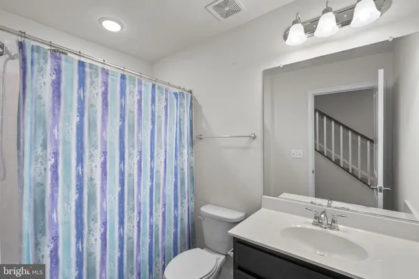 a bathroom with a sink toilet and a mirror