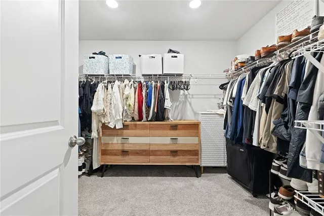 a view of walk in closet with clothes and shoes