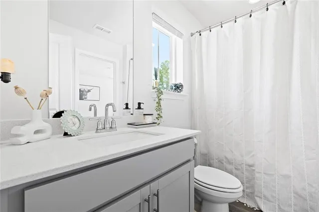 a bathroom with a sink a toilet and a mirror