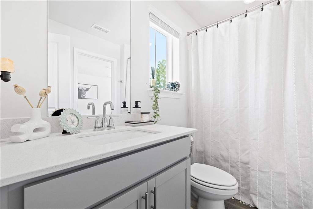 4167 Waratah Way Mableton, GA 30126 - Photo 20 of 32 a bathroom with a sink a toilet and a mirror