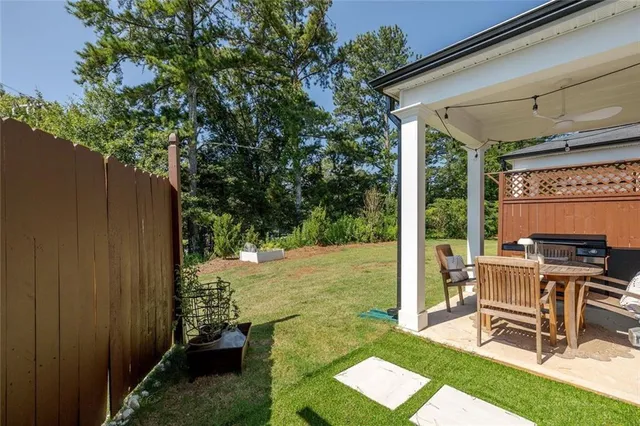a view of a chair and table in backyard of the house