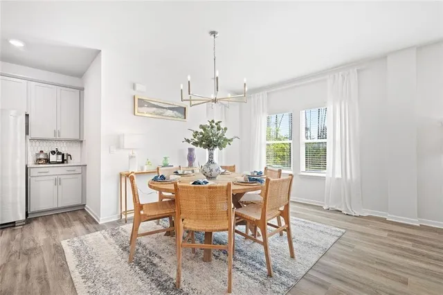 a dining room with furniture a chandelier and wooden floor