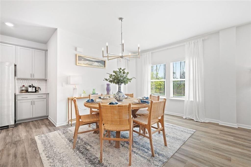 4167 Waratah Way Mableton, GA 30126 - Photo 6 of 32 a dining room with furniture a chandelier and wooden floor