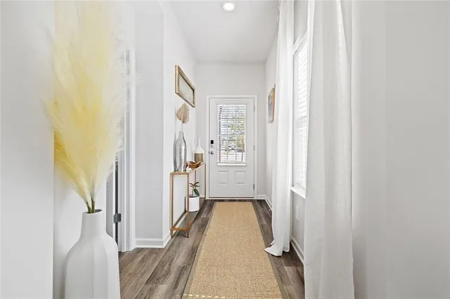 a view of a hallway with wooden floor and staircase