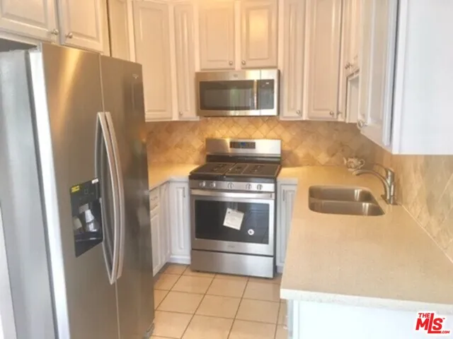 a kitchen with granite countertop a refrigerator and a stove