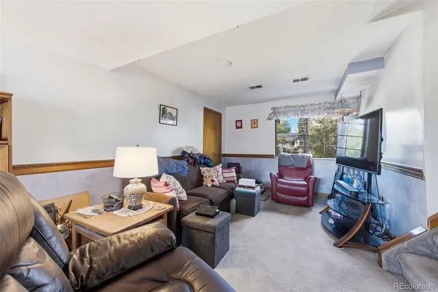a living room with furniture a flat screen tv and a window