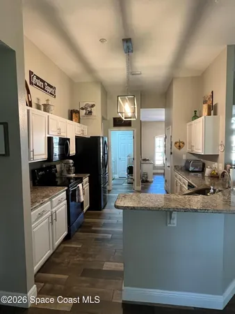 a large kitchen with stainless steel appliances kitchen island granite countertop a refrigerator a stove top oven a sink and dishwasher