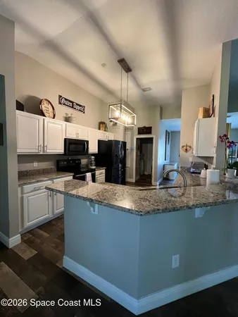 a kitchen with stainless steel appliances granite countertop a sink a stove and a microwave