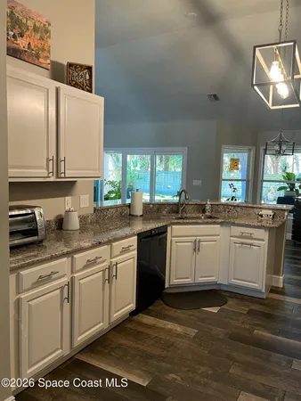 a kitchen with granite countertop a sink stainless steel appliances and cabinets