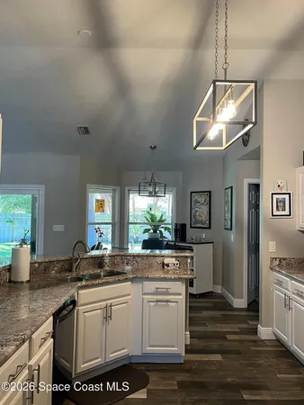 a kitchen with a white cabinets and chandelier