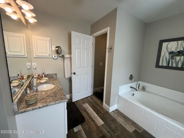 a spacious bathroom with a granite countertop tub sink and mirror