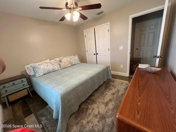 a spacious bedroom with a bed and a chandelier