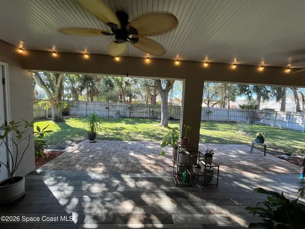a view of a patio with a table chairs and a backyard