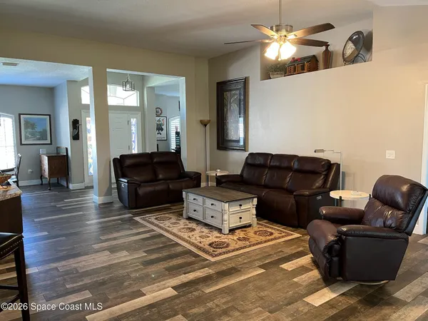 a living room with furniture ceiling fan and a rug