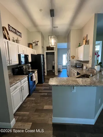 a large kitchen with stainless steel appliances kitchen island granite countertop a stove a sink dishwasher and a refrigerator