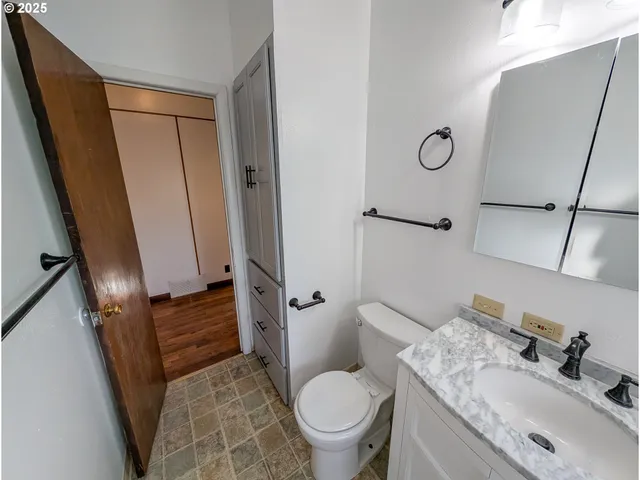 a bathroom with a granite countertop sink toilet and shower a mirror