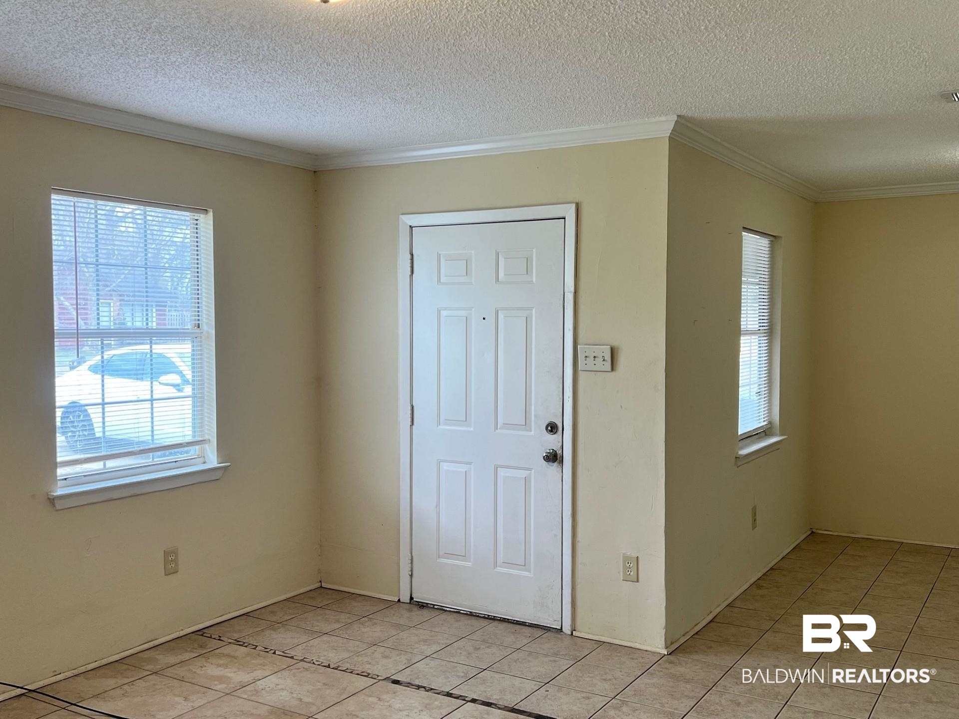 72 Grimes Lane Loxley, AL 36551 - Photo 6 of 12 Entryway with crown molding, a textured ceiling, and light tile patterned floors