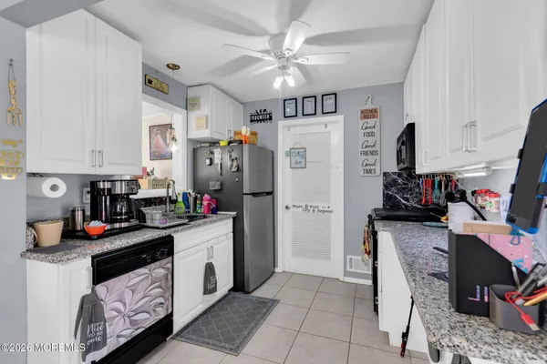 a kitchen with a refrigerator a stove top oven a sink and cabinets