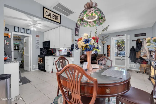 a dining room filled chandelier and wooden floor