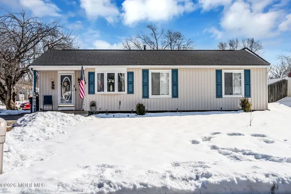 a front view of a house with a yard covered in snow