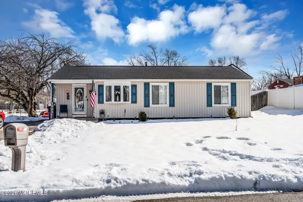 a front view of a house with a yard covered in snow