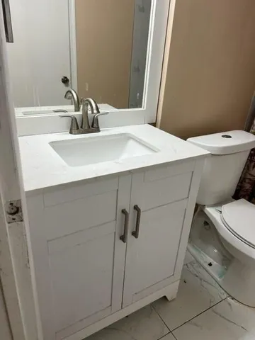 a bathroom with a sink a toilet and mirror