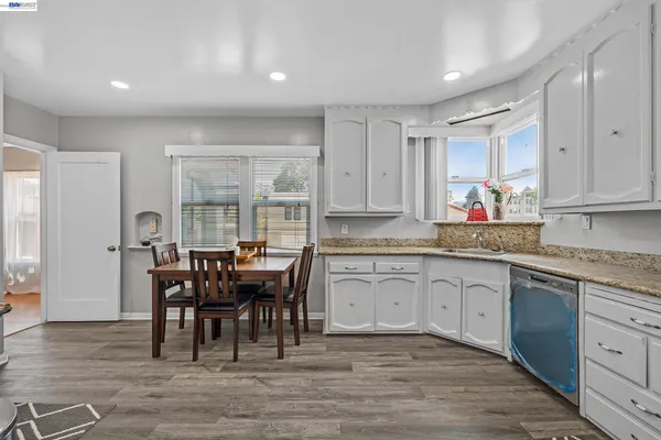 a kitchen with stainless steel appliances granite countertop a dining table chairs and granite counter tops