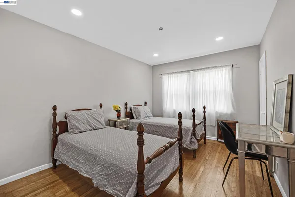 a bedroom with two beds and wooden floor