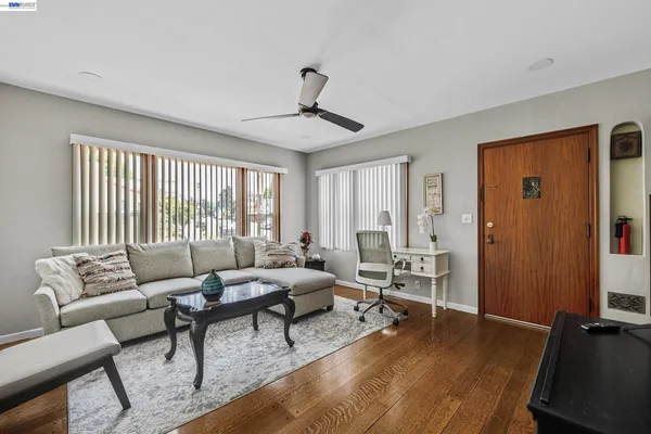 a living room with furniture and wooden floor