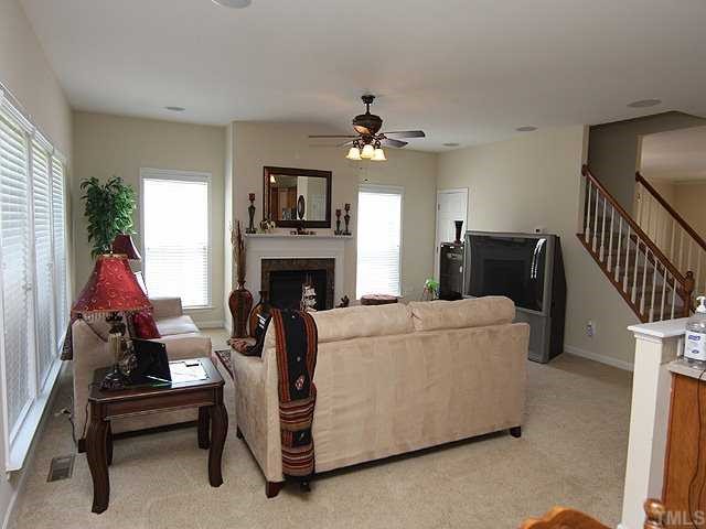131 Locke Woods Road Raleigh, NC 27603 - Photo 15 of 18 a living room with furniture a fireplace and a flat screen tv