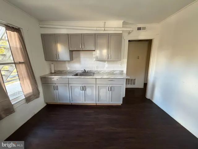 a kitchen with a sink a window a stove and cabinets