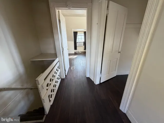 a view of a hallway with wooden floor and staircase