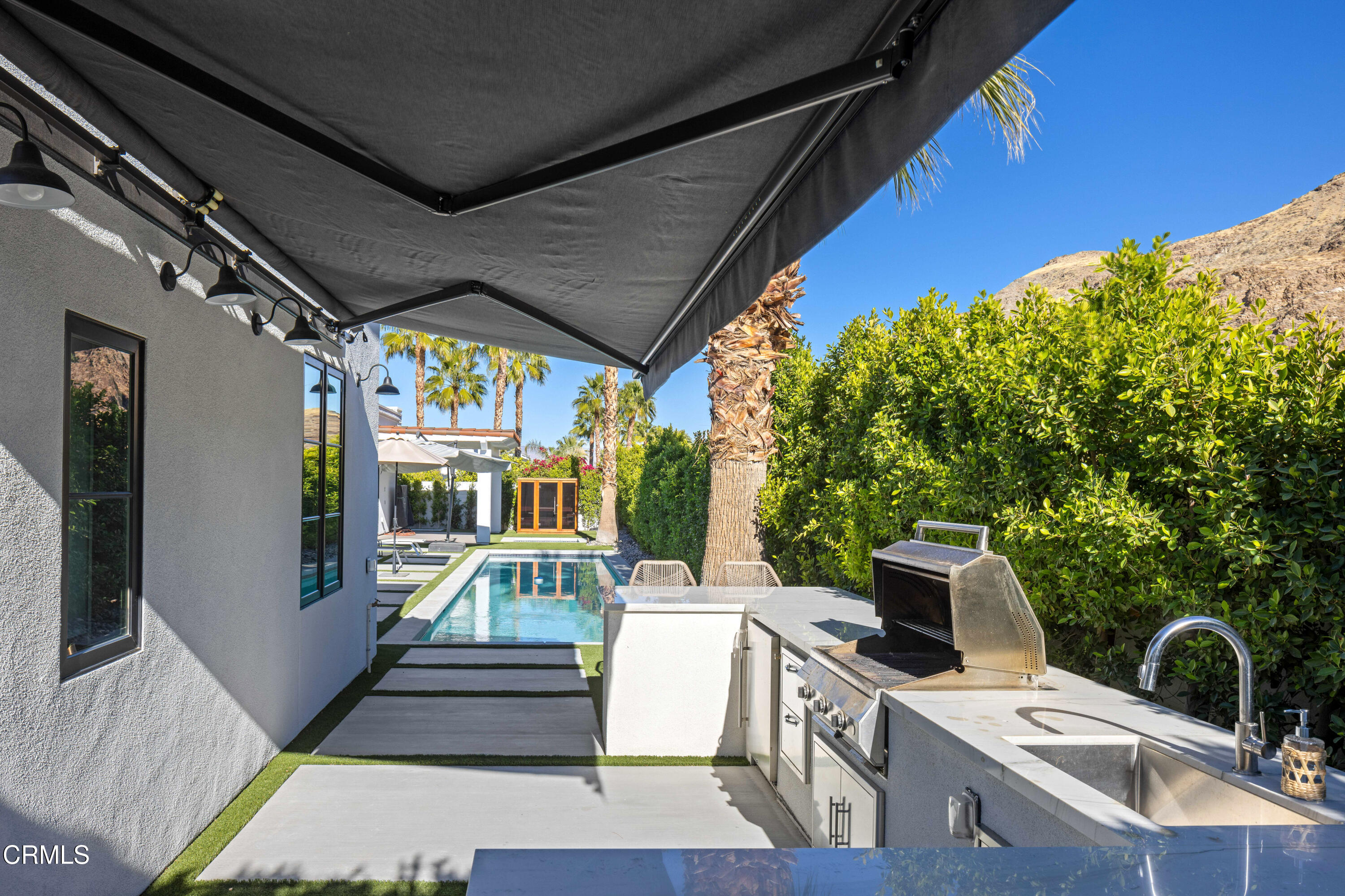 3076 Arroyo Seco Palm Springs, CA 92264 - Photo 15 of 37 a view of a patio with table and chairs potted plants with wooden floor