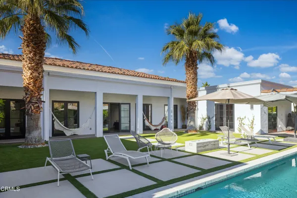 a view of a house with swimming pool and porch with furniture