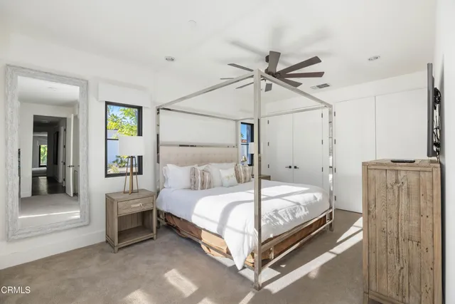 a bedroom with a large bed and a chandelier