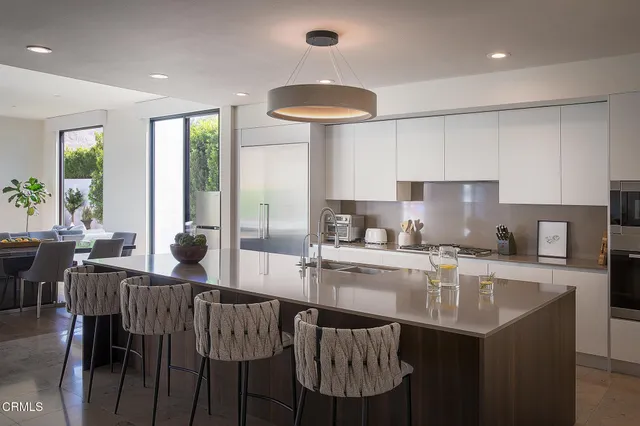 a kitchen with granite countertop a table chairs stove and microwave